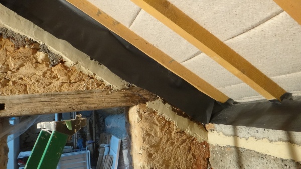 Préparation des murs pour le collage de la membrane et protection capillaire pour l&#039;isolant contre un mur de refend pouvant être humide