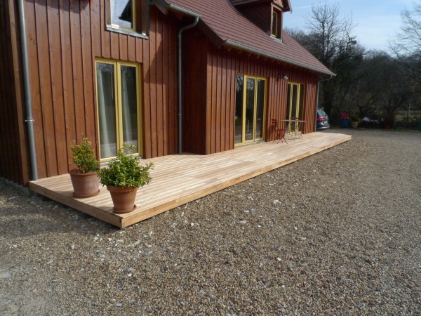 Terrasse en lames d&#039;acacia (imputrescible classe IV) directement posée sur la terre à l&#039;aide de plots réglables